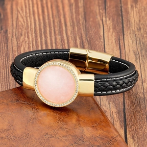 Dettaglio della chiusura dorata e pietra rosa sul bracciale in pelle nera