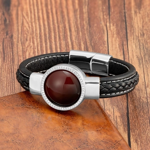 Détail d'une pierre d'agate rouge avec zircone sur un bracelet en cuir tressé noir
