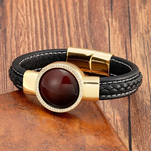 Dettaglio del bracciale in pelle nera intrecciata con chiusura magnetica e gemma rossa