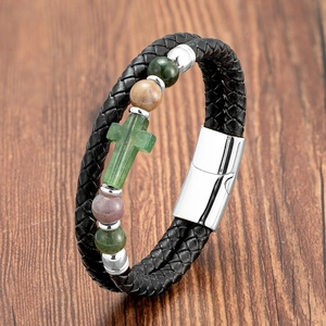 Detail eines zweisträngigen Lederarmbandes mit grünem Steinkreuz und Magnetverschluss