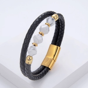 Detail of men's braided black leather bracelet with white marble beads and gold magnetic clasp