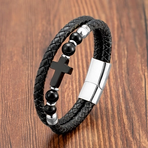 Detailansicht von mehrlagigem schwarzem Lederarmband mit Kreuzanhänger und Magnetverschluss