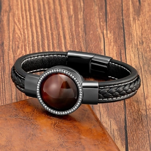 Dettaglio macro del bracciale in pelle nera da uomo con pietra marrone e zirconi