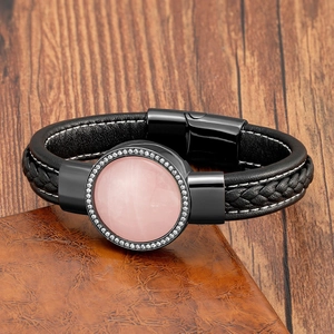 Dettaglio di bracciale in pelle con pietra rosa e zircone su una base di legno