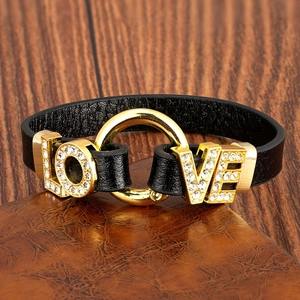 Détail d'un bracelet en cuir noir avec lettres LOVE dorées serties de cristaux fins