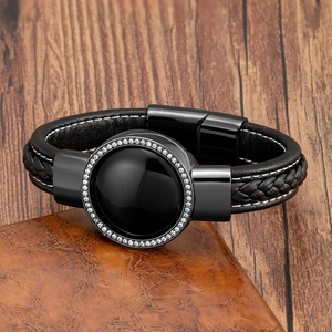 Dettaglio macro del bracciale da uomo in pelle nera intrecciata con pietra nera e cristalli
