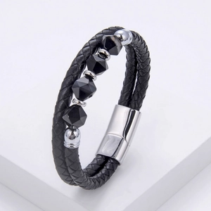 Close-up of woven leather bracelet with black geometric beads and silver metal clasp