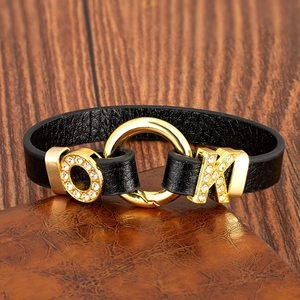 Bracelet en cuir tendance avec lettres OK dorées et cristaux sur une table en bois