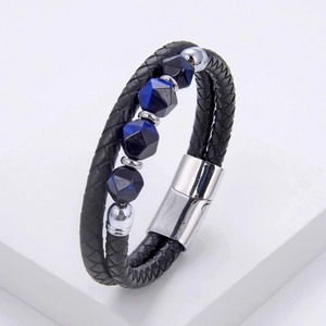 Detail of men's braided black leather bracelet with blue beads and silver magnetic clasp