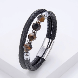 Detailed macro view of black braided leather bracelet with tiger eye stones and metal clasp