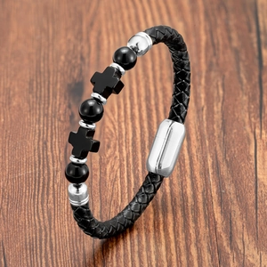 Detail of black woven leather bracelet featuring black beads and silver cross charms