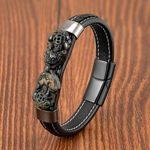 Dettaglio ravvicinato del bracciale da uomo in pelle intrecciata con occhio di tigre e acciaio