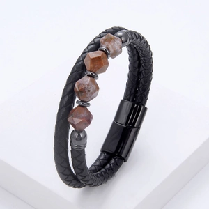 Detail of men's braided leather bracelet featuring brown natural stones and magnetic clasp