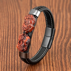 Dettaglio del bracciale in pelle intrecciata da uomo con ciondoli PiXiu in occhio di tigre rosso