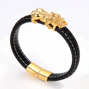 Detail of woven black leather bracelet with golden Pixiu charm and magnetic clasp