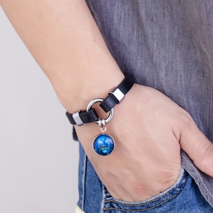 Detail shot of a black braided leather Leo zodiac bracelet on a model's wrist