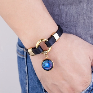 Pisces constellation leather bracelet with golden charm on wrist for men and women