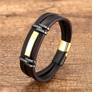 Detail van een meerlaagse bruine leren armband met goudkleurig metaal en magneetsluiting