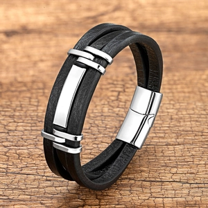 Detail van een meerlaagse zwarte lederen armband met een zilveren metalen magneetsluiting