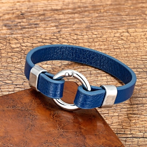 Detail of navy blue leather bracelet with polished silver metal ring buckle on wood