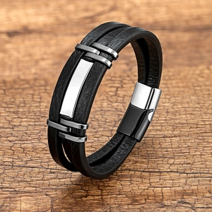 Detail van een meerlaagse zwart gevlochten leren armband met zilveren magnetische sluiting