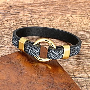 Close-up of black leather bracelet with grey woven texture and golden metal clasp