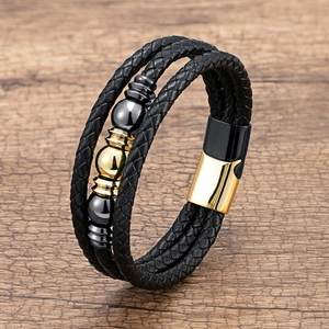 Vue détaillée d'un bracelet en cuir tressé multicouche avec fermoir magnétique noir et or
