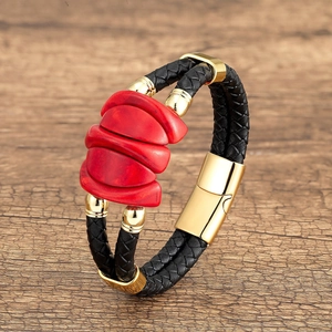 Detail of black woven leather bracelet with red stone and gold magnetic clasp