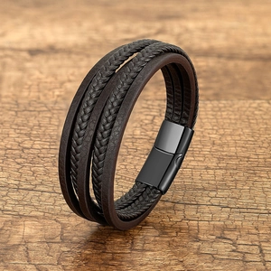 Detail of multi-layer dark brown braided leather bracelet with black magnetic clasp