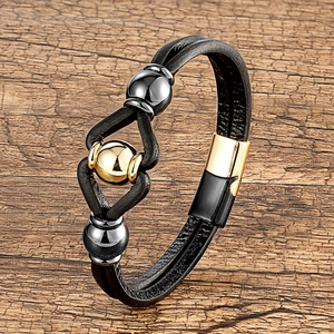 Détail du bracelet multicouche en cuir tressé avec des perles en métal poli et fermoir