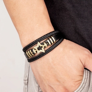 Multi-layer black leather bracelet featuring a gold star charm with sparkling crystals