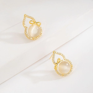 Boucles d'oreilles gourde en pierre œil de chat dorées avec zircons et nœud papillon