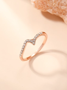 Macro shot of rose gold wave ring with sparkling white zircon stones on stone prop