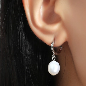 Elegant silver pearl drop earrings worn by a model showcasing a minimalist luxury style