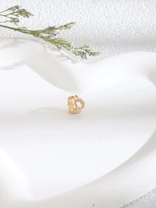 Detail of gold U-shaped moon nose clip with white zircon in a heart-shaped dish