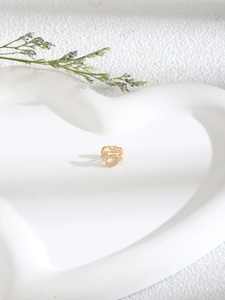 Detailed macro view of golden crescent moon and star zircon non-piercing U-shaped nose ring