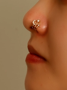 Detail shot of a gold non-pierced U-shaped nose cuff with moon and star zircon inlay