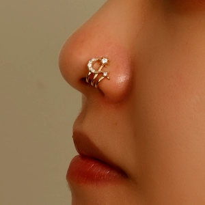 Macro side view of gold moon and star non-pierced nose cuff set with cubic zirconia stones