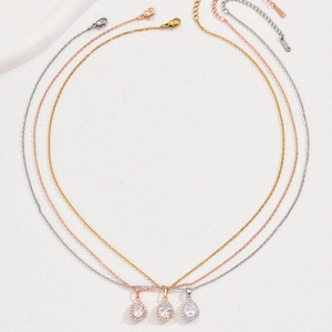 Trois colliers avec pendentifs goutte en zircon, finitions argent, or et or rose