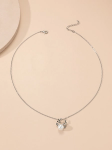 Detailed macro view of silver reindeer antler necklace with pearl and lobster clasp closure