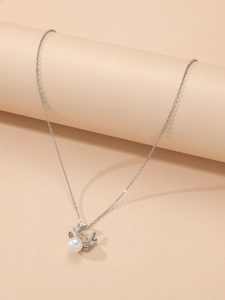 Detail of silver reindeer necklace with central white pearl and sparkling crystals