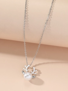 Detailed view of silver reindeer necklace featuring a large pearl and sparkling rhinestones
