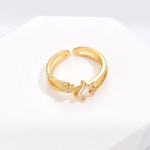 Detailed macro of gold irregular double-band open ring with rectangular zircon stone