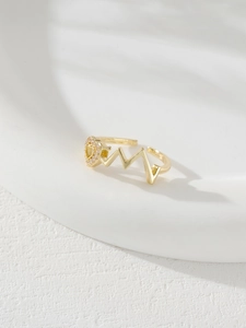 Detailed view of gold heartbeat wave ring with micro-pave heart shaped yellow zircon