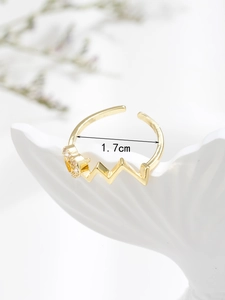 Detail view of gold wavy heartbeat ring with zircon accent and 1.7cm inner diameter