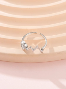 Macro detail of wave-shaped silver heart ring with sparkling cubic zirconia inlay