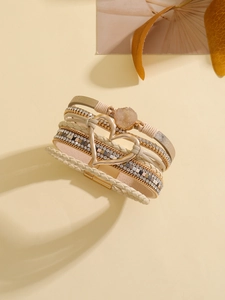 Detalle de pulsera bohemia multicapa con corazón de cristal y cierre magnético
