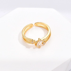 Irregular open gold ring featuring a rectangular zircon and star-set accents