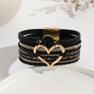 Detalle de la pulsera multicapa de cuero bohemio con un corazón de cristal negro y cierre magnético