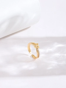 Macro detail of gold knot ring featuring sparkling zircon pavé and adjustable open band